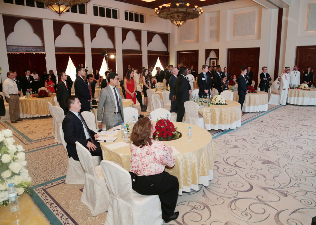 Formal event with attendees seated at round tables.